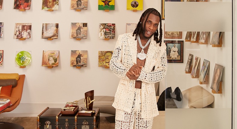 Burna Boy poses against the backdrop of old records for Architectural Digest