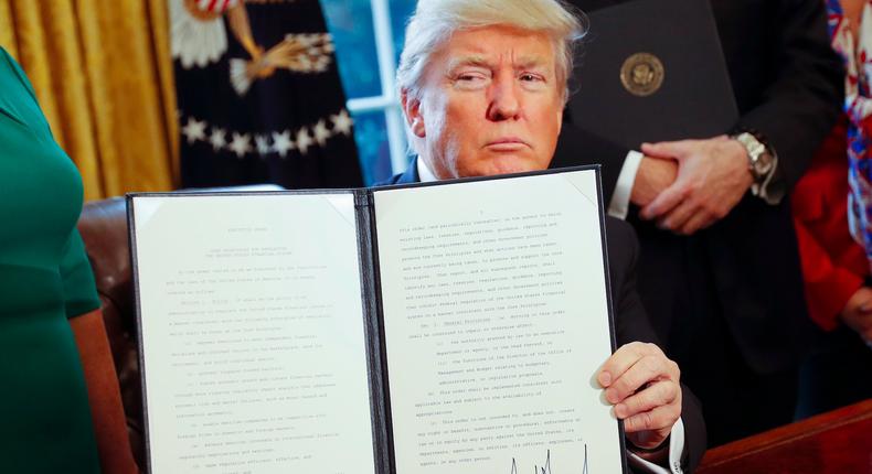 President Donald Trump signs an executive order in the White House.