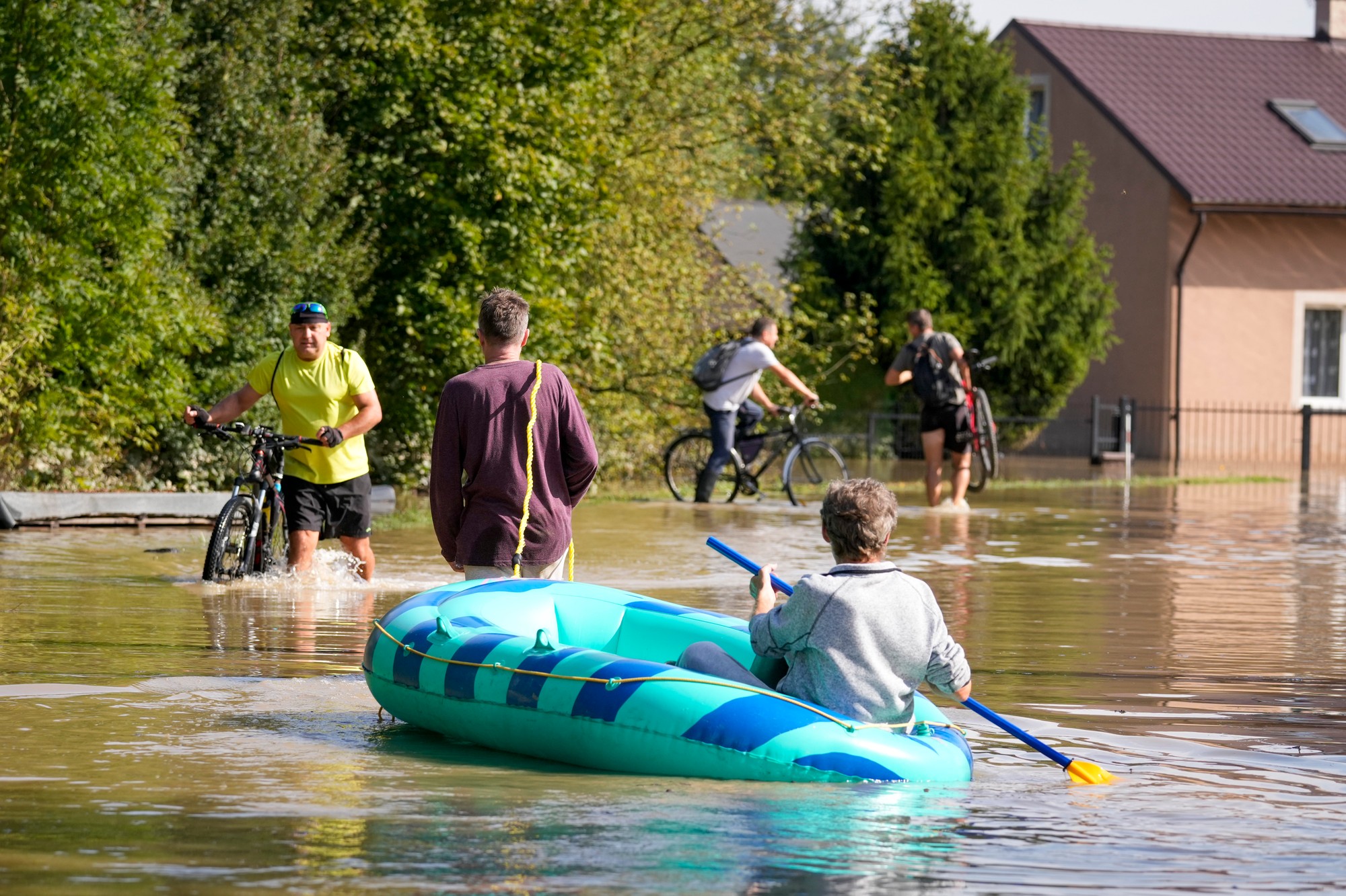 Obyvatelia tlačia svoje bicykle, zatiaľčo ďalší pádlujú cez zaplavenú ulicu v českom Bohumíne.