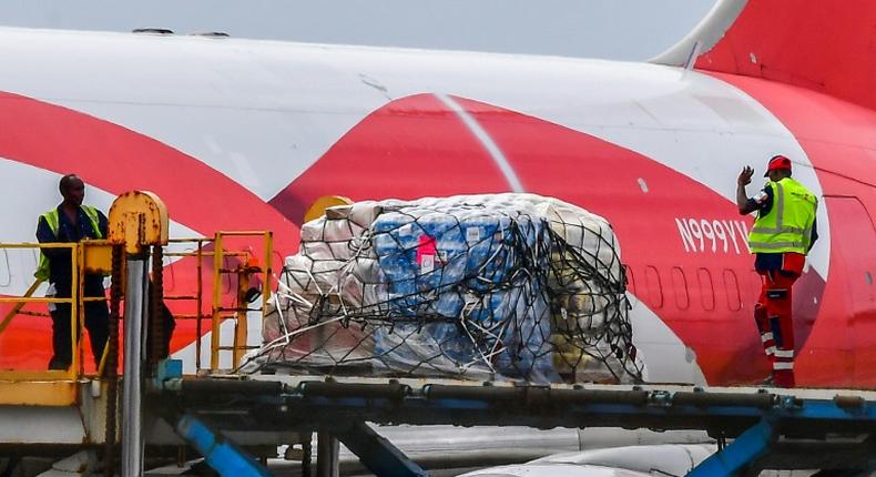 Workers load food and medicals aid for Venezuela from a US Boeing 767 aircraft shortly after landing at the Hato International Airport in Willemstad, Curacao in the Netherlands Antilles on February 21, 2019