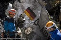 French gendarmes, seen in this picture made available to the press by the French Interior Ministry  work near debris from wreckage showing a German flag at the crash site of an Airbus A320, near Seyne-les-Alpes