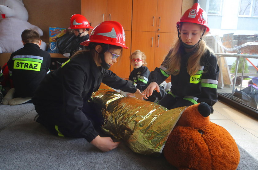 Mali strażacy z OSP Mikołajew w Łodzi ćwiczą udzielanie pierwszej pomocy na pluszowym misiu