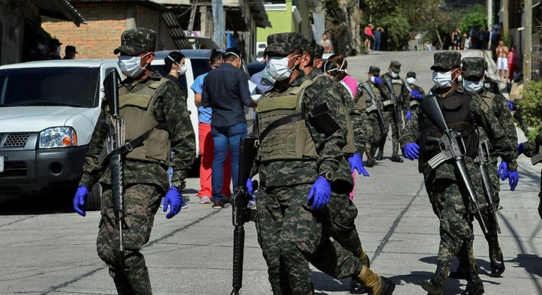 Soldiers assist health personnel in Tegucigalpa, Honduras on March 17, 2020 after two new cases of the new coronavirus were confirmed