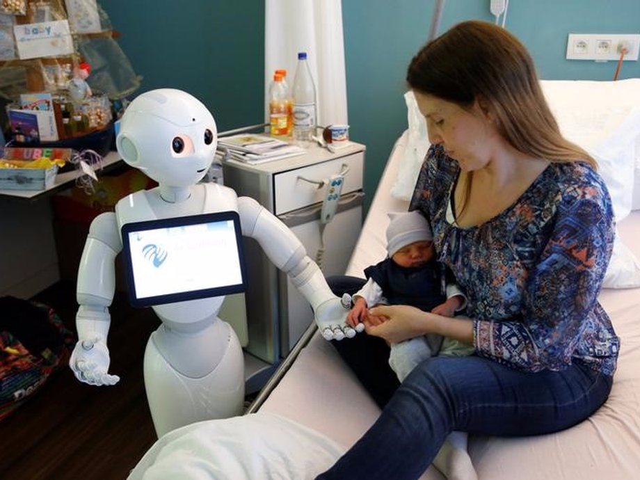 Pepper holding the hand of a newborn baby next to his mother at AZ Damiaan hospital in Ostend, Belgium.