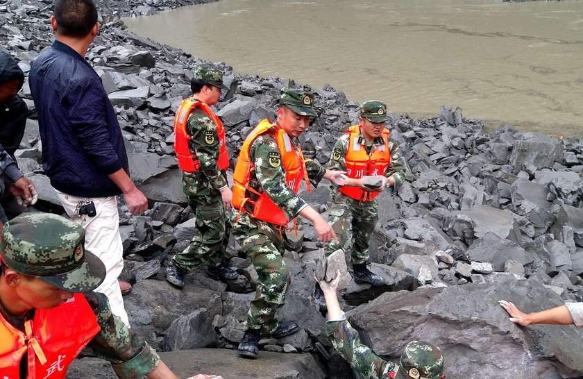 People search for survivors at the site of a landslide that occurred in Xinmo Village