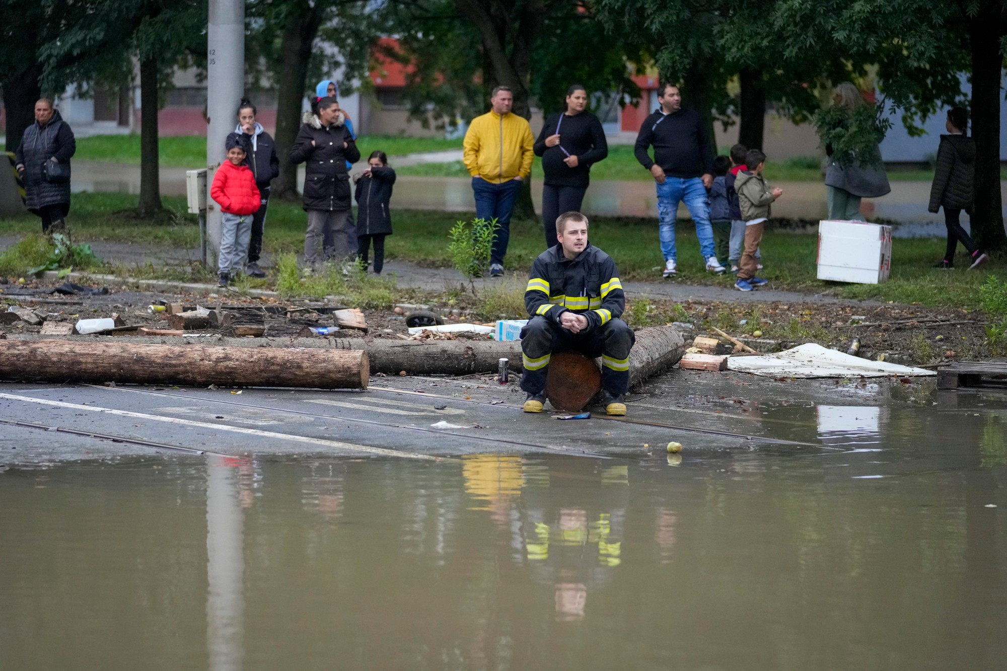 Hasič a obyvatelia sa pozerajú na záplavu v Ostrave.