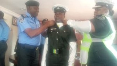 CP Idowu Owohunwa decorating promoted Insp. Ajara Isede of the Lagos Police Traffick Division on Thursday in Lagos. [(NAN]