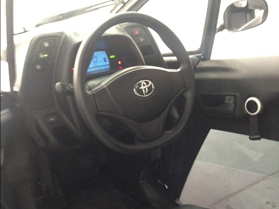 .... and you'll find a conventional driver's cockpit, complete with steering wheel, turn indicators, and accelerator and brakes pedals. It's even got the interior door handles from a Camry.