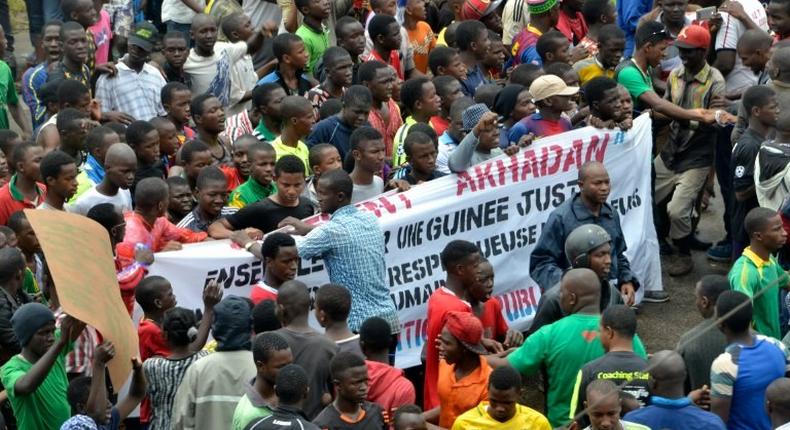 Guinean opposition supporters march with banners during an anti-government protest in Conakry on August 16, 2016 