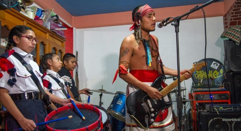 Victor Hugo Sandoval (R), vocalist and guitarist of Mexican rock band Los Cogelones, rehearses with his students -- members of a marching band -- in Ciudad Nezahualcoyotl, Mexico state, Mexico, on August 12, 2020