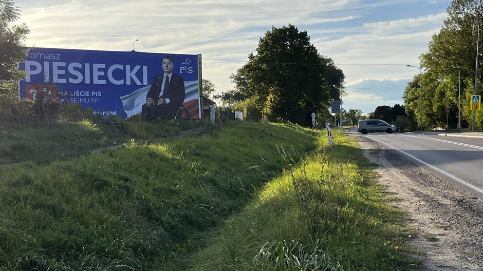 Fasty pod Białymstokiem i DK nr 65 w kierunku Ełku. Billboard stoi naprzeciwko przystanku autobusowego i cerkwi