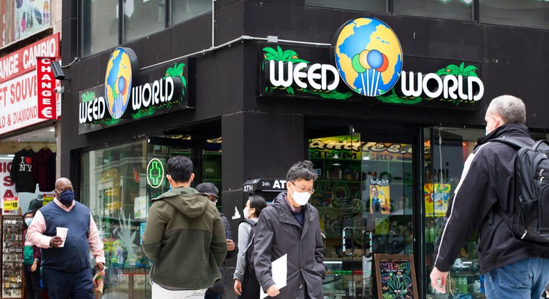 People walk past the Weed World store on March 31, 2021, in Midtown Manhattan, New York City. Despite the shop's name, it doesn't sell any products containing THC.
