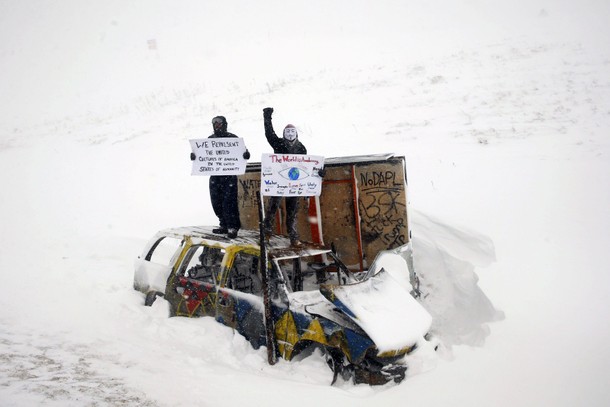 Veterans and activists march to Backwater Bridge just outside the Oceti Sakowin camp during a snow f