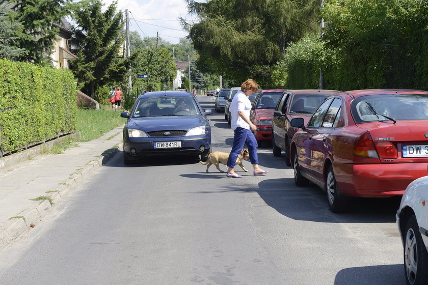 Pieszy przechodzi przez ulicę przed samochodem