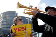 Demonstrators take part in a protest in front of the European Parliament as MEPs debate on modificat