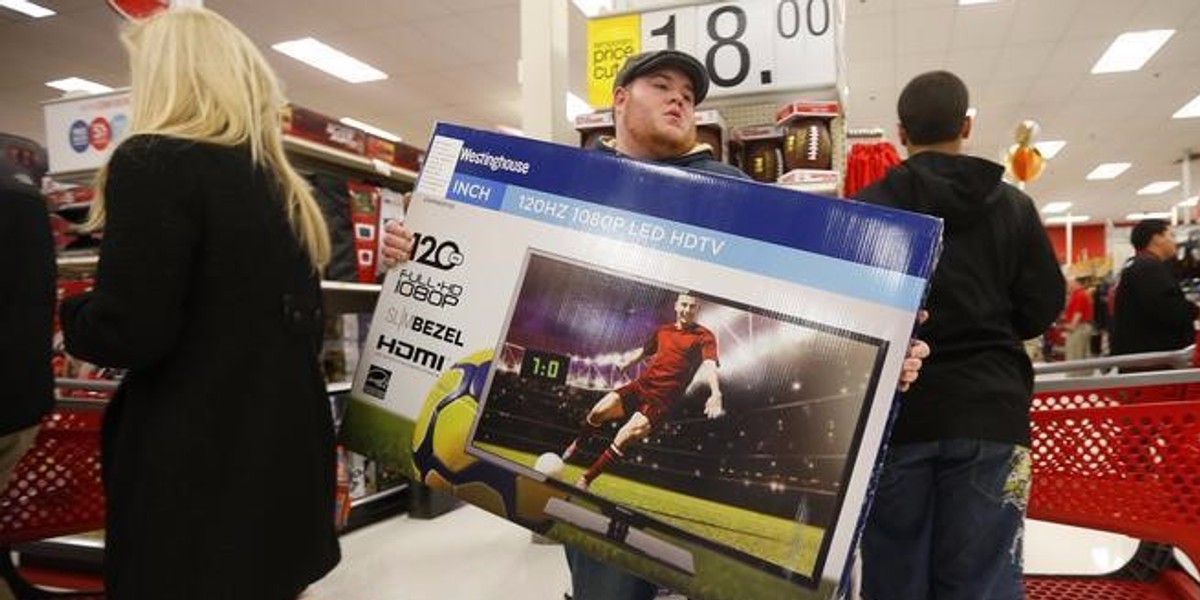 Thanksgiving Day holiday shopper carries a discounted television to the checkout at the Target retail store in Chicago