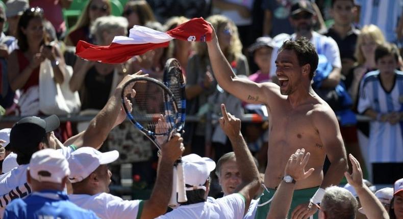 Italy's tennis player Fabio Fognini waves his jersey celebrating with teammates after defeating Argentina's Guido Pella on February 6, 2017