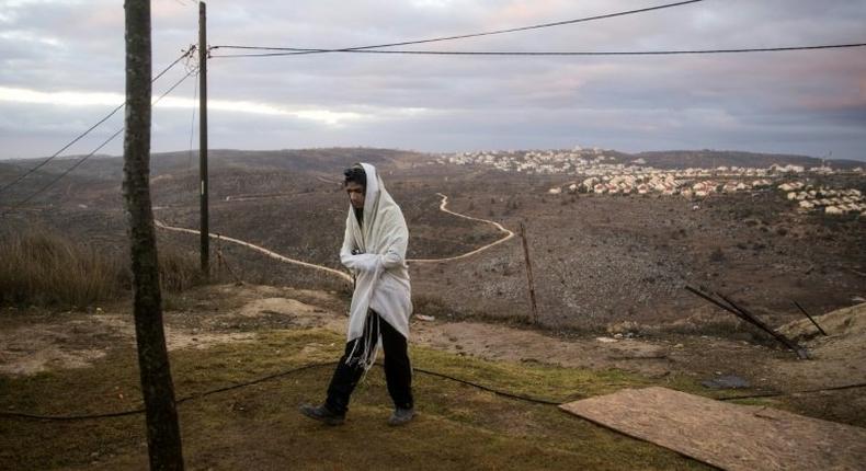 A young Israeli settler prays in the settlement outpost of Amona, in the Israeli-occupied West Bank