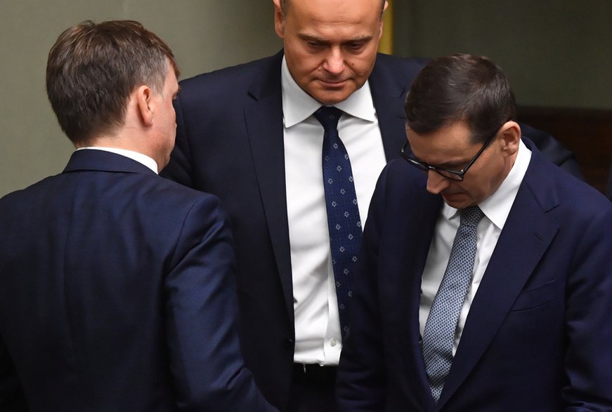 Premier Mateusz Morawiecki (P), minister sprawiedliwości, prokurator generalny Zbigniew Ziobro (L-tyłem) oraz poseł PiS Andrzej Kosztowniak (C) na sali obrad Sejmu w Warszawie