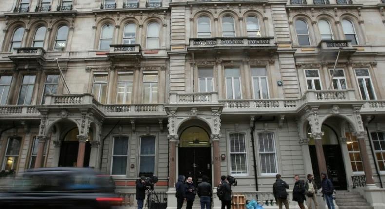 Journalists gather outside the London building housing the offices of Christopher Steele