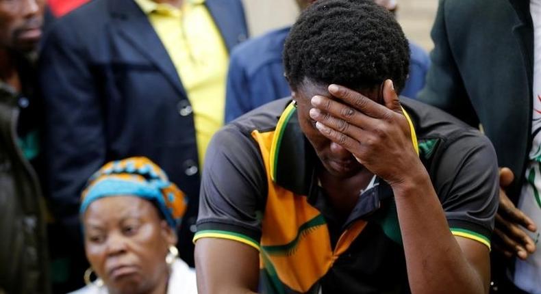 Victor Rethabile Mlotshwa reacts next to his mother after the appearance of Theo Martins and Willem Oosthuizen (not in picture), at the Middelburg magistrates high Court, in Mpumalanga province, South Africa, November 16, 2016. REUTERS/Siphiwe Sibeko