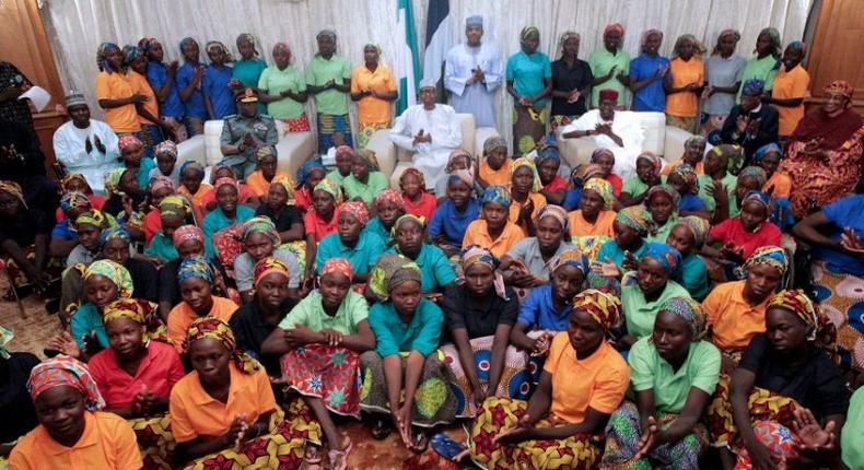 Nigeria's President Muhammadu Buhari (C) sitting among the 82 rescued Chibok girls during a reception ceremony at the Presidential Villa in Abuja, on May 7, 2017