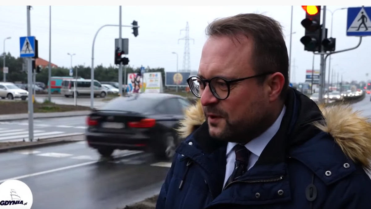 Gdynia: Wiceprezydent mówi o bezpieczeństwie, w tle auto przejeżdża na czerwonym