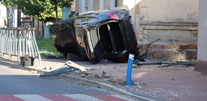 Terenowa beemka skosiła słupki i wylądowała na boku, uderzając w staruszkę. 90-letnia piesza w ciężkim stanie