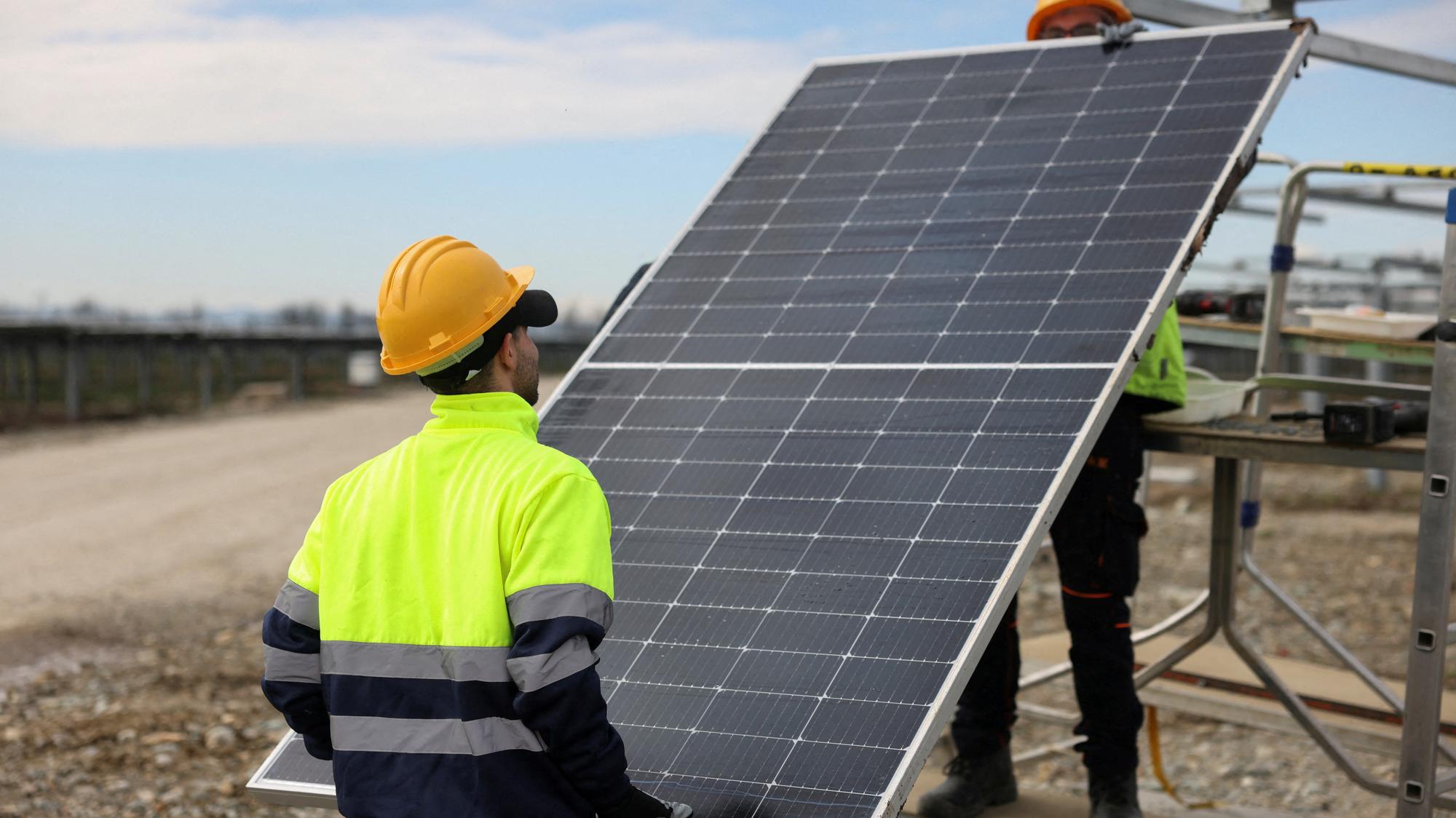 Robotníci inštalujú solárny panel