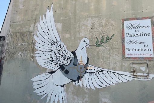 Betlejem. Mural Banksy'ego „Gołąb pokoju w kamizelce kuloodpornej