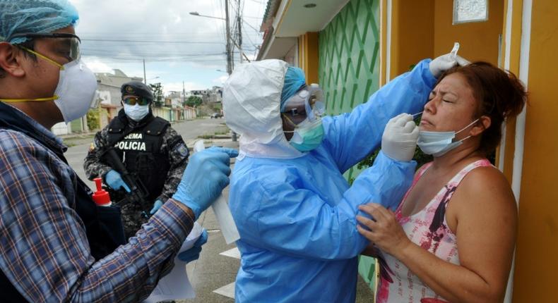 Health ministry personnel test a woman for the novel coronavirus in northern Guayaquil, Ecuador, on April 19, 2020
