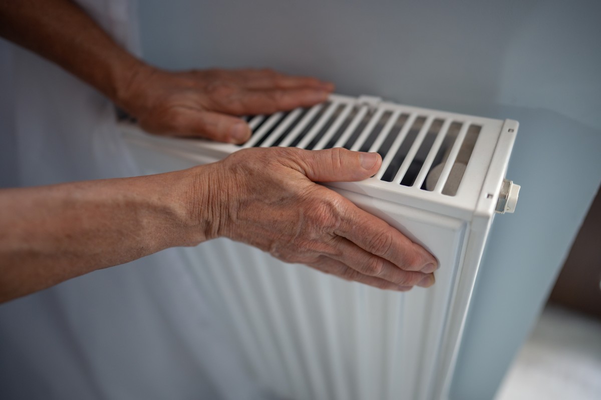 Kaloryfery zimne ciepłe odpowietrzanie konserwacja kaloryferów grzejników grzejniki Close-up,Of,Mature,Woman,Hands,Touching,Radiator,,Checking,For,Heat
