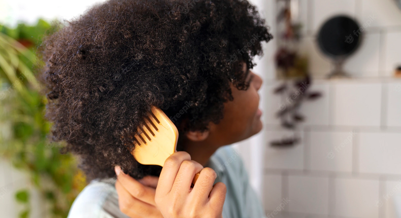 Jeune africaine prenant soin de ses cheveux afro