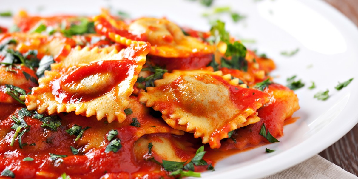 Ravioli with tomato sauce garnished with parmesan cheese and basil