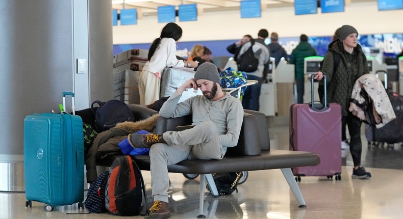 Michael Ricchiuti waits in Salt Lake City after his flight was canceled by snow Wednesday.AP/Rick Bowmer