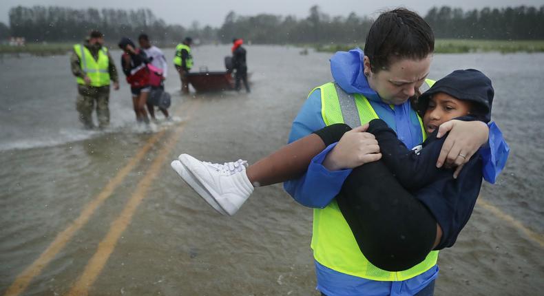 A volunteer worker rescues a child and her family during Hurricane Florence.