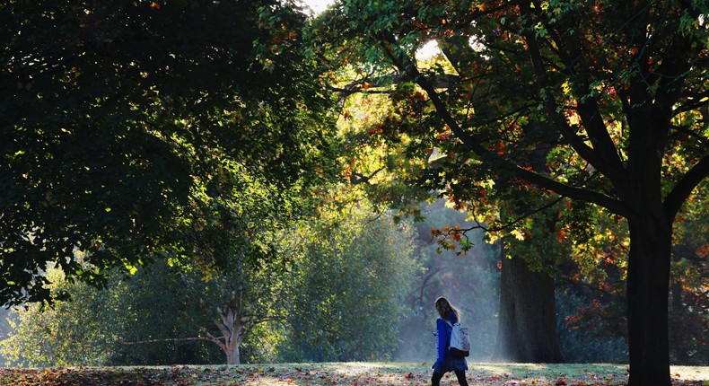 Woman walking through the park in the morning