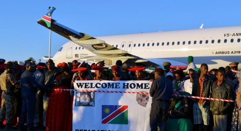 Protesters hold a banner at Windhoek international airport calling for reparations from Germany, on October 4, 2011