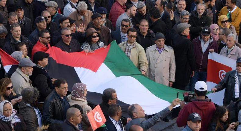 Tunisian demonstrators carry a Palestinian flag during a protest against US President Donald Trump's Middle East peace plan on February 5, 2020