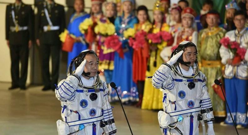 Chinese astronauts Jing Haipeng (L) and Chen Dong salute during the send-off ceremony of the Shenzhou-11 manned space mission, at the Jiuquan Satellite Launch Center in north-western Gansu Province, on October 17, 2016