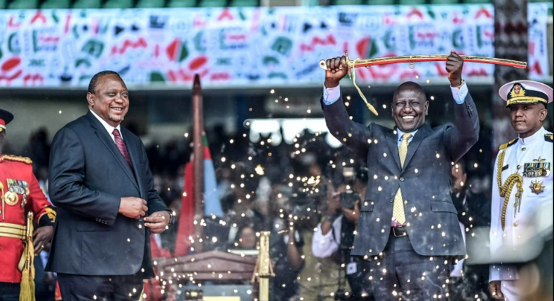 President Willliam Ruto raises the ceremonial sword after handover by former President Uhuru Kenyatta