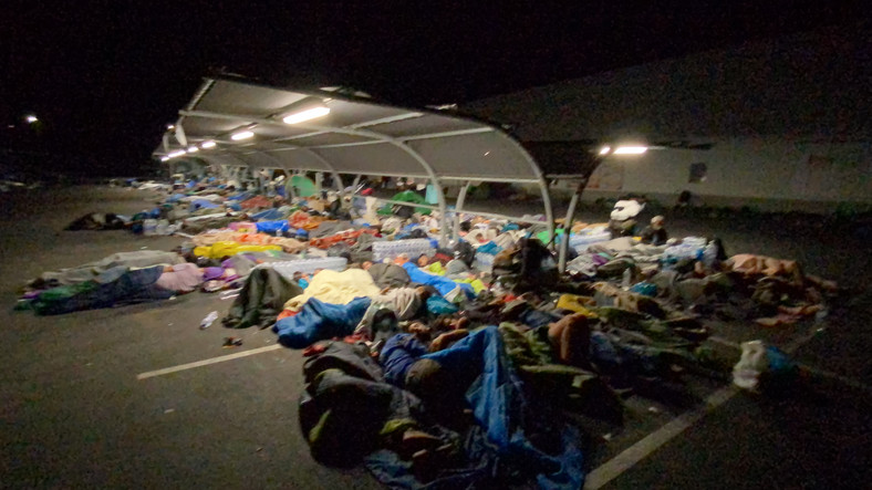 Uchodźcy nocujący pod wiatą parkingową