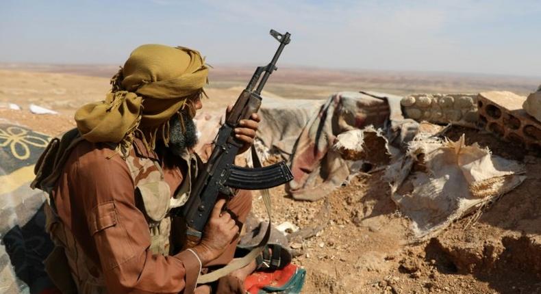 A rebel fighter takes position in a trench in the area of Al-Eis in northern Syria on October 7