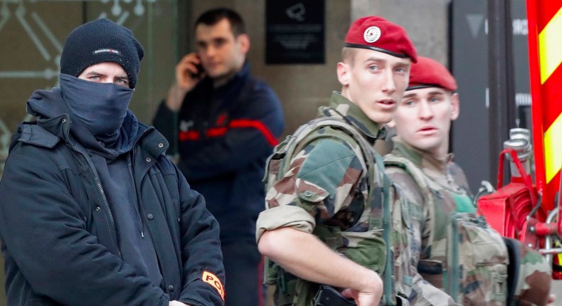 French police officers, soldiers, and firefighters in front of the street entrance of the Carrousel du Louvre in Paris on Friday.