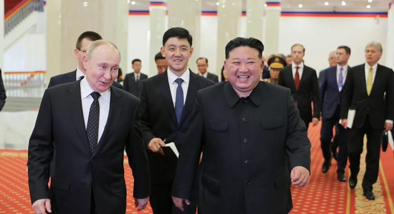 Vladimir Putin and Kim Jong Un walk to their seats to watch a performance in North Korea.North Korean State Media