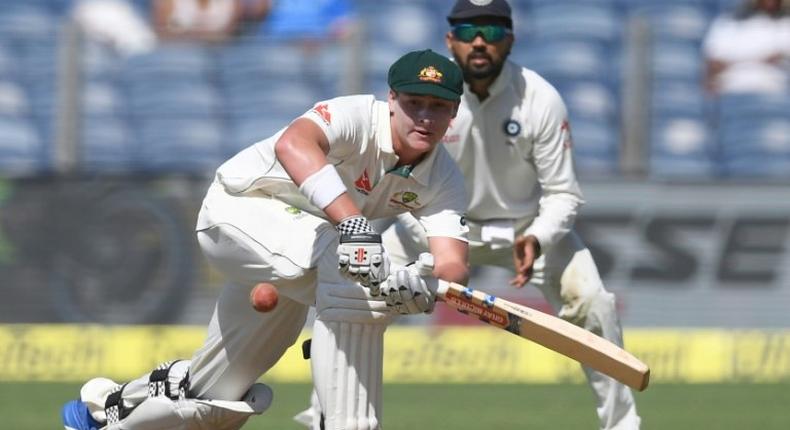 Australia's Matthew Renshaw plays a shot as India's Murali Vijay (R) watches on as during the first day of the first Test at The Maharashtra Cricket Association Stadium in Pune on February 23, 2017