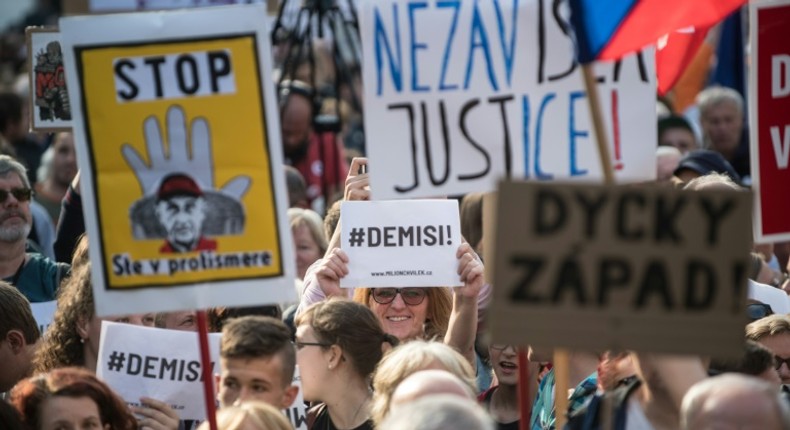 A demonstrator holds a placard reading #Demisi (C) during a protest against the government led by Andrej Babis in Wenceslas Square in Prague, Czech Republic on May 21, 2019