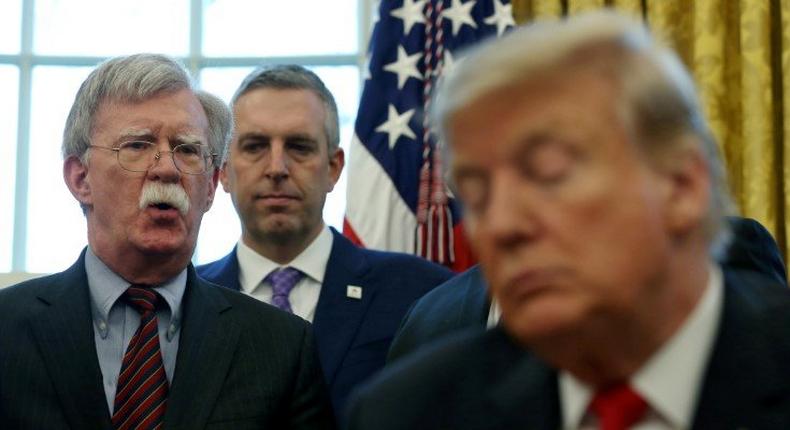 FILE PHOTO: U.S. President Donald Trump listens as his national security adviser John Bolton speaks during a presidential memorandum signing for the