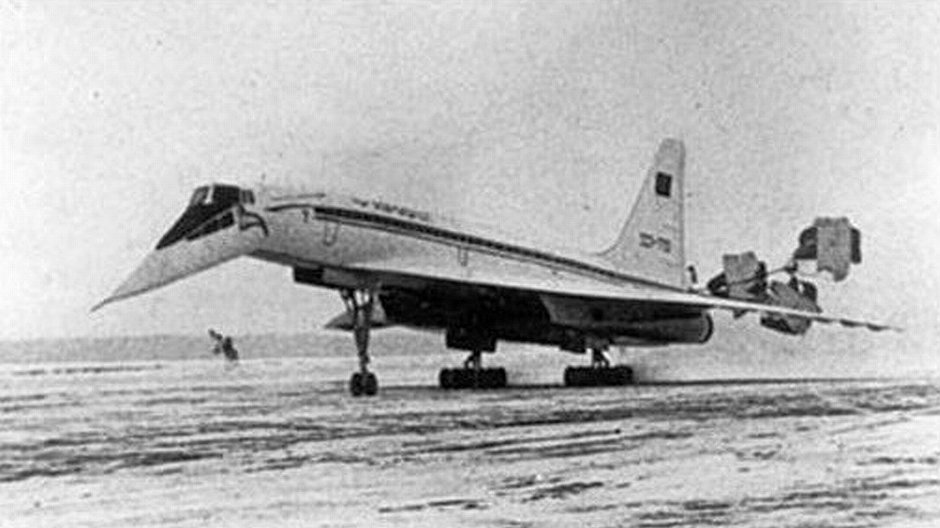 Tu-144 podczas lądowania z widocznymi spadochronami hamującymi i opuszczonym nosem.