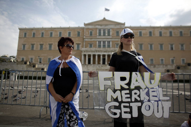 Protestantki stojące przed greckim parlamentem z plakatem "Frau Merkel Get Out" przed wizytą Angeli Merkel, niemieckiej kanclerz w Atenach.